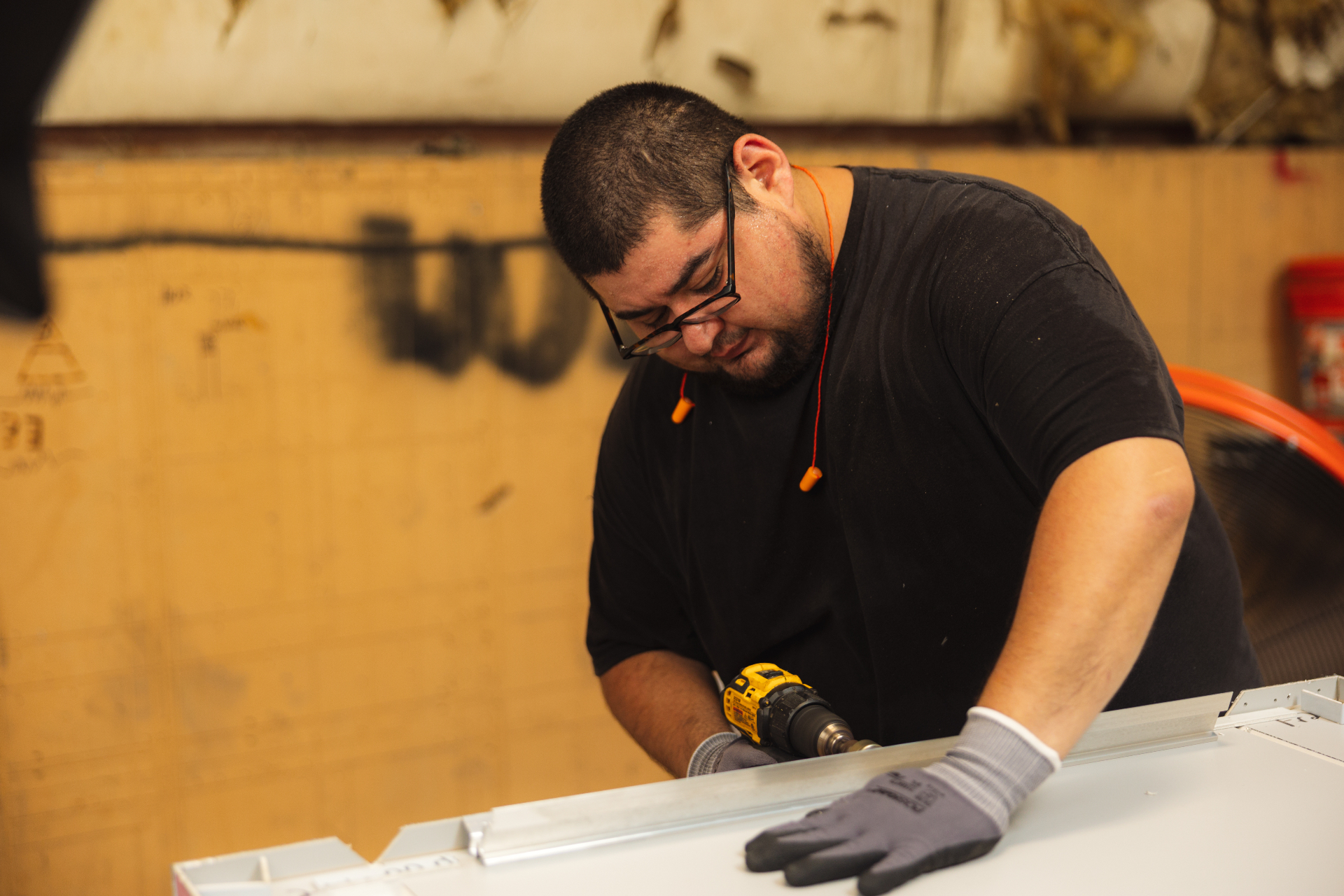 A Build United craftsman drilling at the shop bench