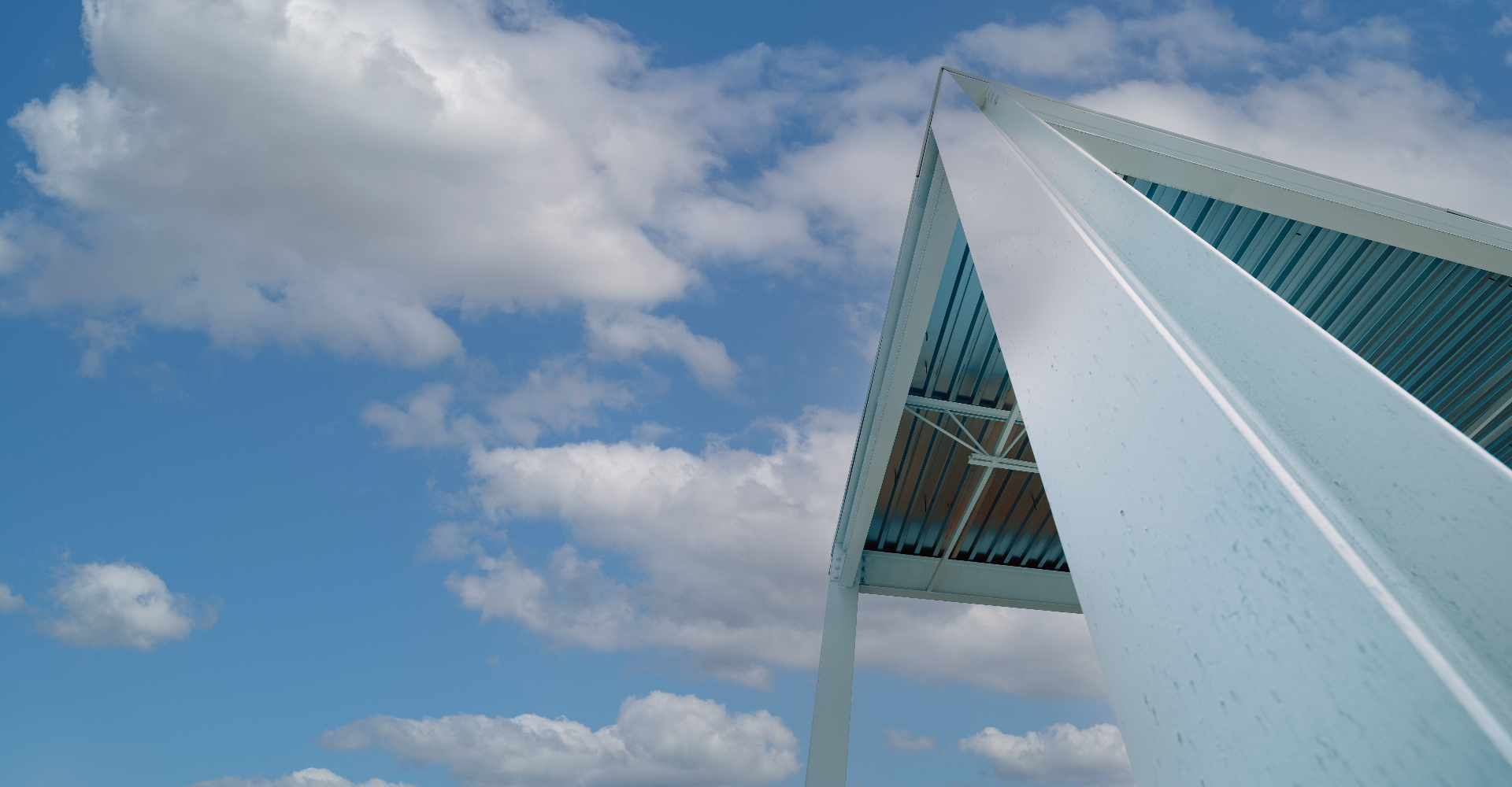 A pitched steel canopy against a bright sky — Build United