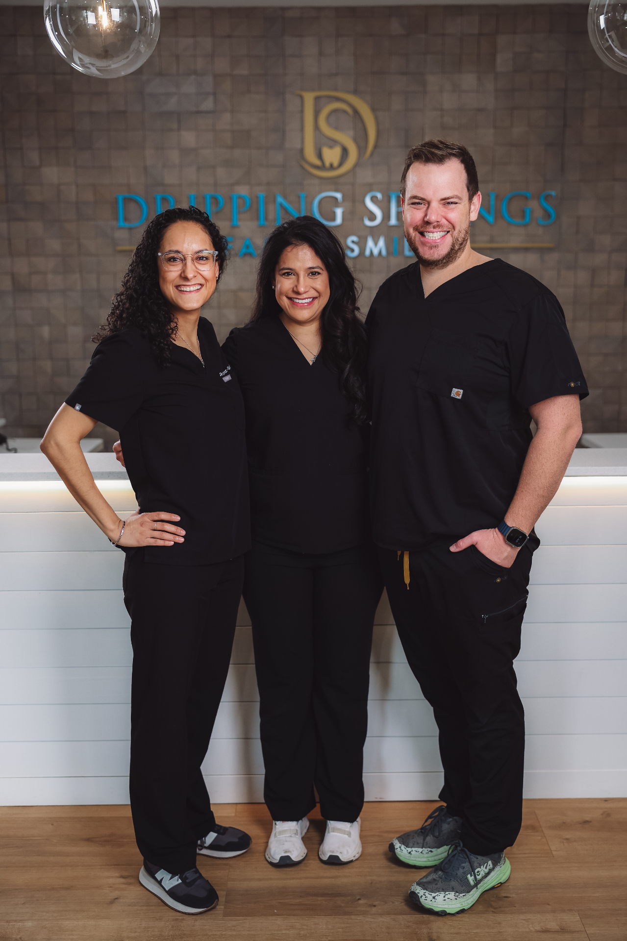 The doctors and team behind the practice, standing together at the front desk