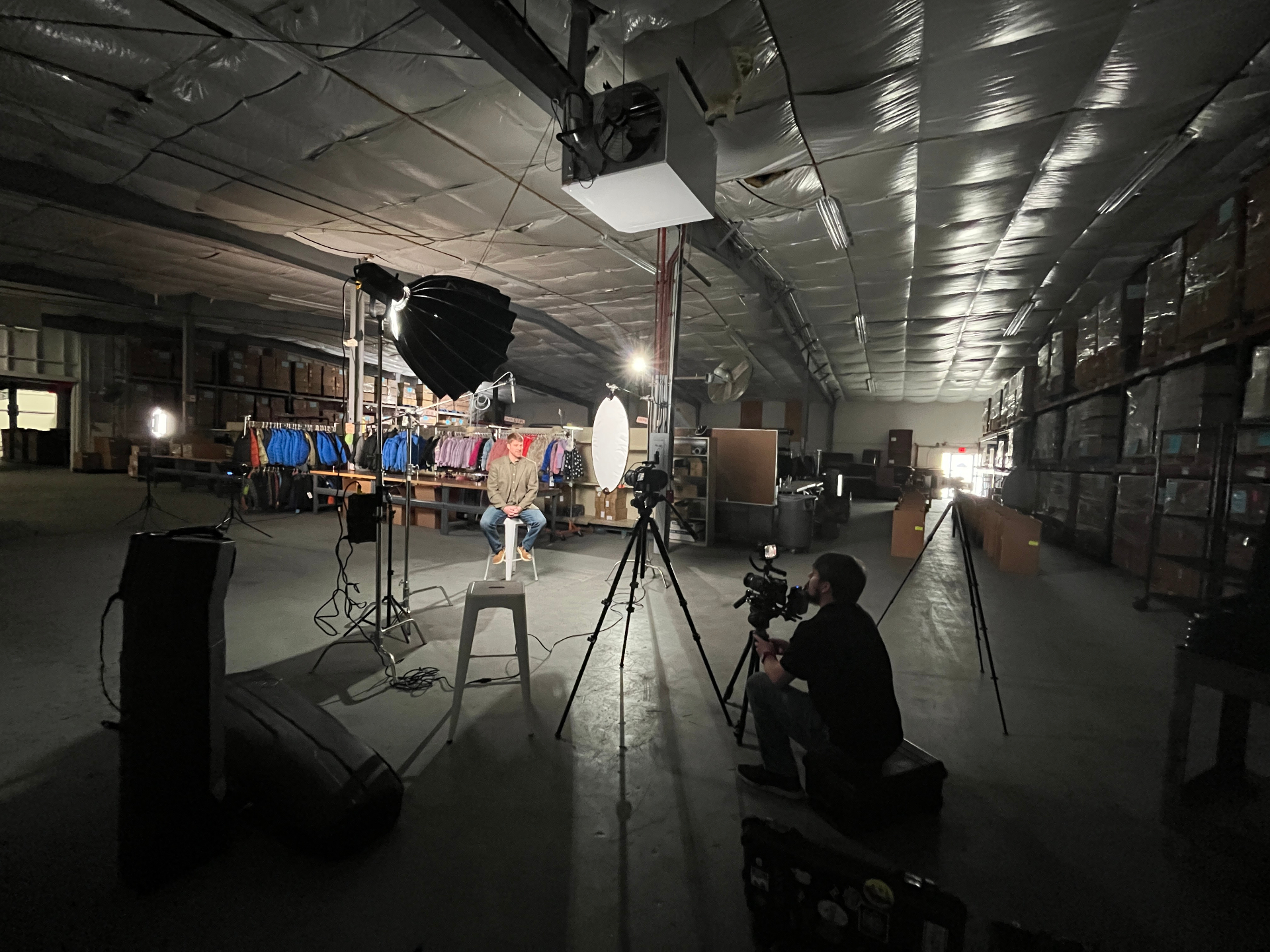 A small crew lighting an interview inside a warehouse
